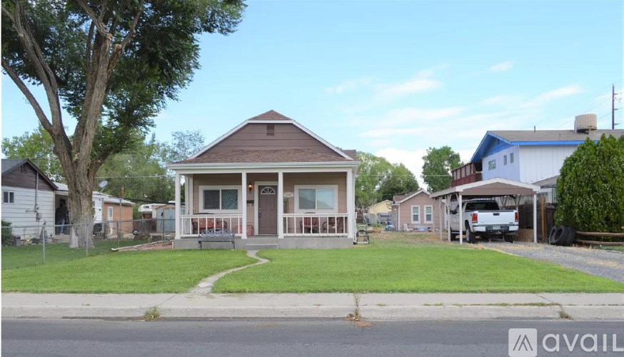 A house with a brown roof and a porch is for sale.