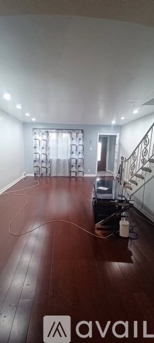 A room with a wooden floor and a staircase.