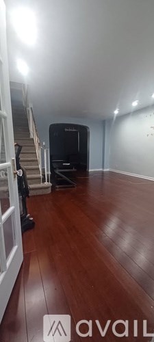 A room with wooden floors and a staircase.