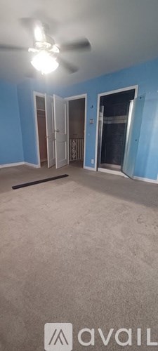 A room with blue walls and a ceiling fan.