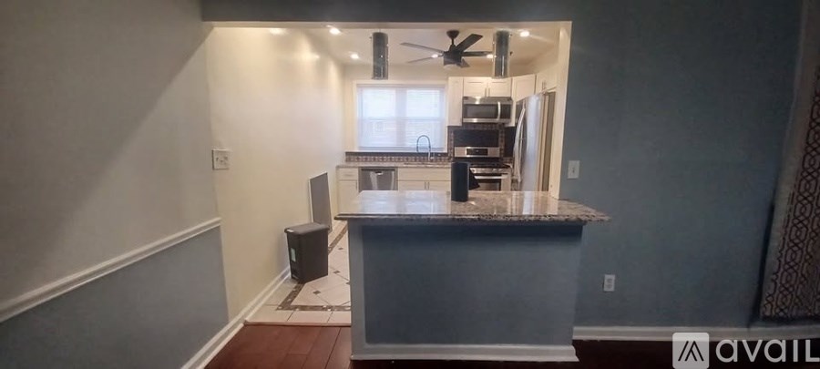 A kitchen with a granite countertop and a refrigerator.
