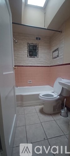 A bathroom with a toilet, sink, and bathtub.