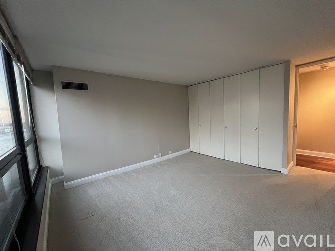 A room with white walls and a grey carpet.