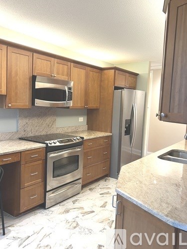 A kitchen with a stove, oven, refrigerator, and microwave.
