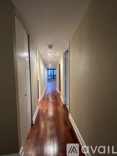 A long hallway with wooden floors and white walls.