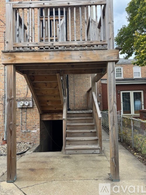 A wooden staircase leads down to a basement under a house.