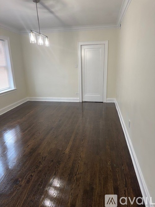 A room with wooden flooring and a white door.