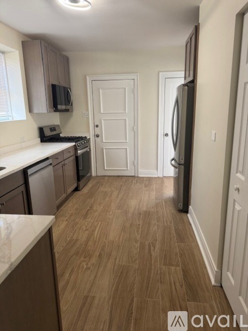 A kitchen with wooden floors and white walls.