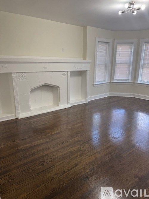 A room with a fireplace and wood flooring.