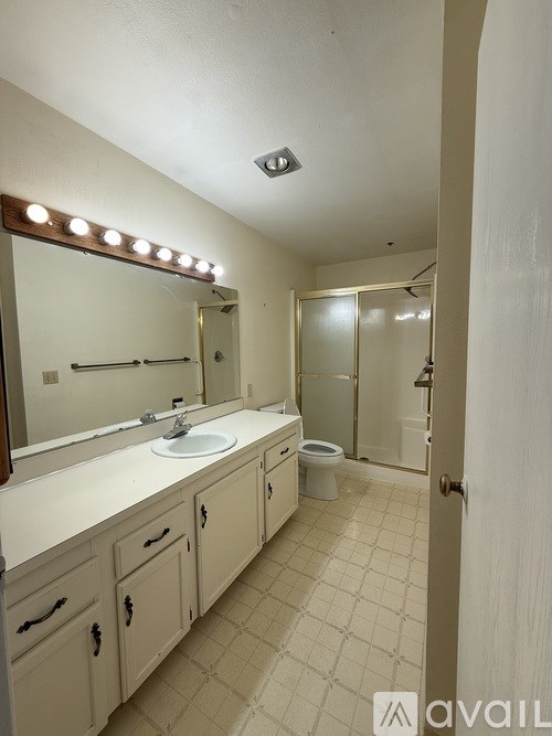 A bathroom with a sink, mirror, and toilet.