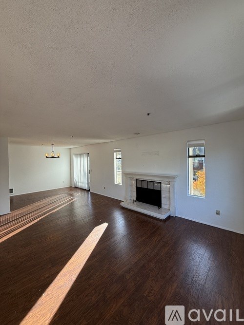 A spacious living room with hardwood floors and a fireplace.
