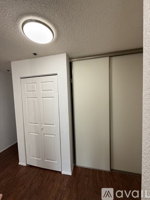 A white door is in a room with a round light on the ceiling.
