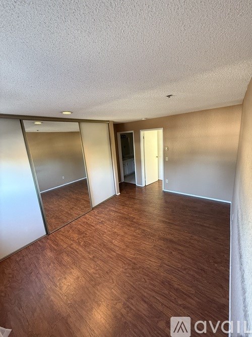 A room with wooden flooring and a sliding door.