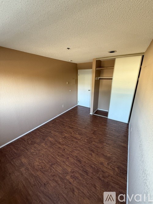 A room with wooden flooring and a white door.