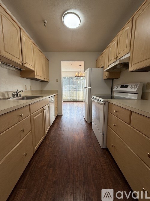 A kitchen with wooden cabinets and a white fridge.