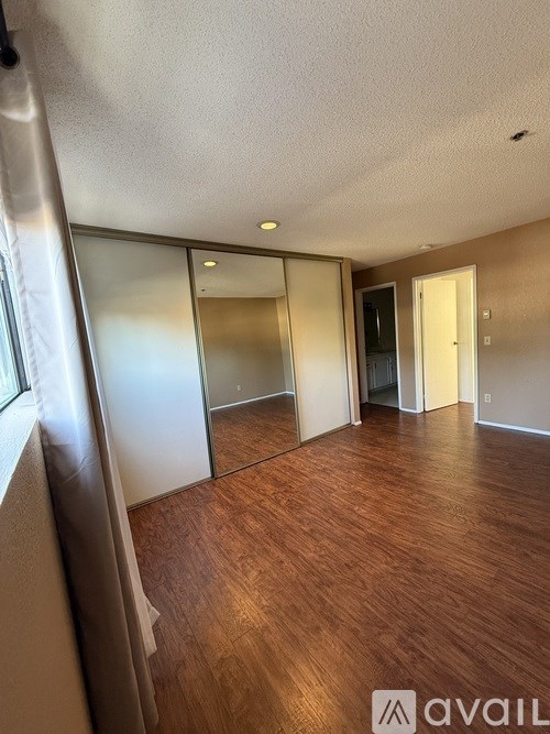 A room with wooden flooring and a glass door.