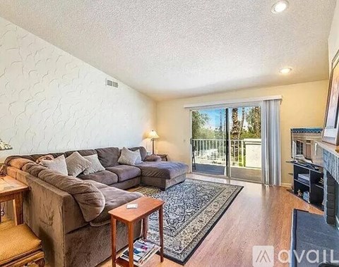 A living room with a grey couch and a wooden coffee table.
