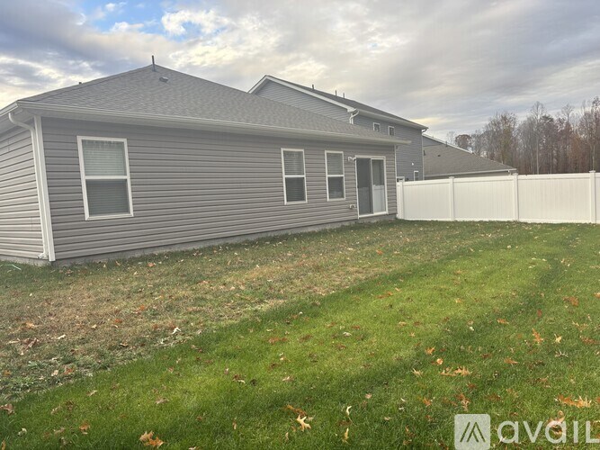 A house with a grey siding and a white fence.