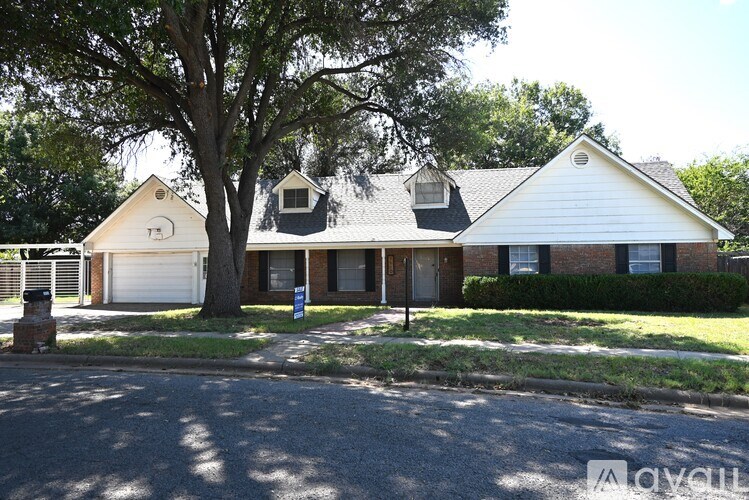 A house with a white roof and a tree in front of it.
