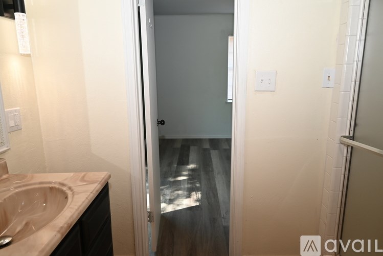 A bathroom with a sink and a door leading to a hallway.