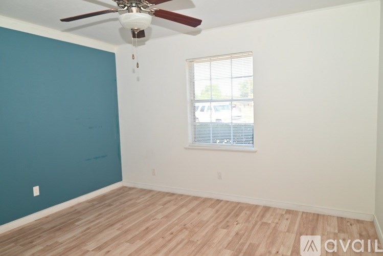 A room with a ceiling fan and a window with blinds.