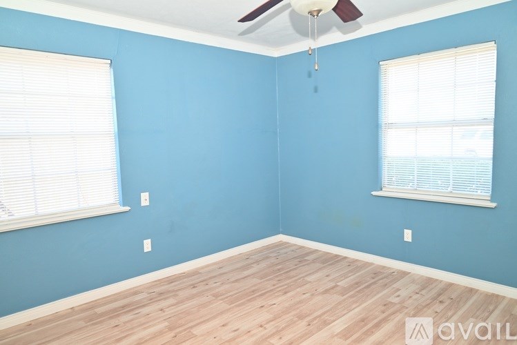 A room with blue walls and wooden flooring is available for rent.