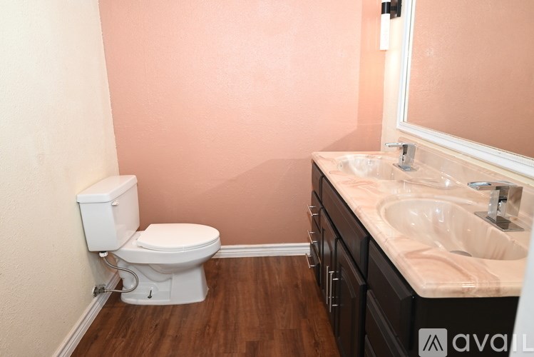 A bathroom with a toilet, sink, and mirror.