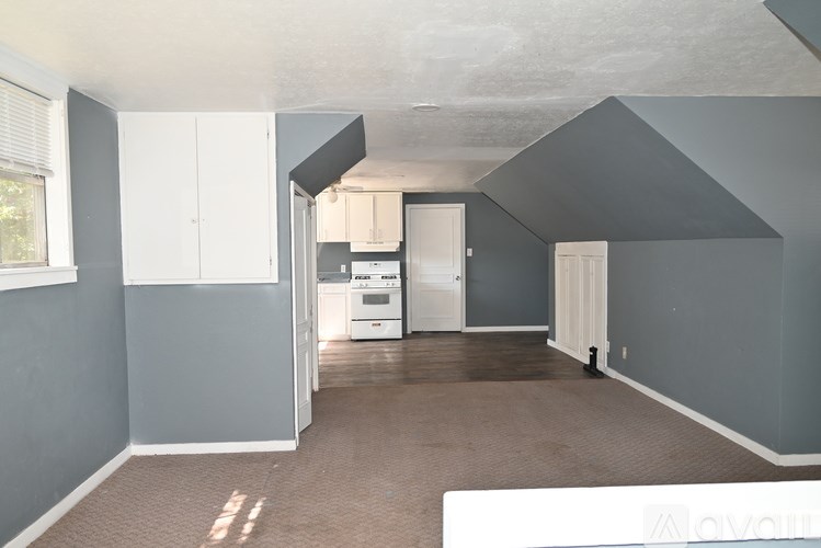 A room with grey walls and a white fridge.