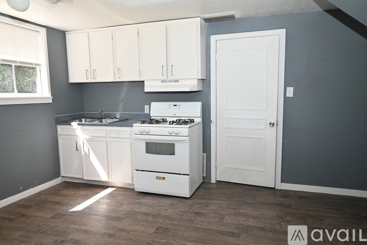 A kitchen with white appliances and cabinets.