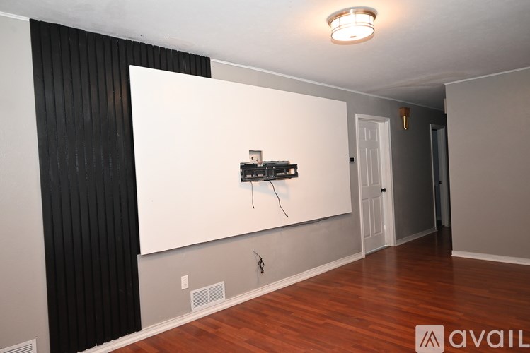 A room with a white wall and a black striped wallpaper.