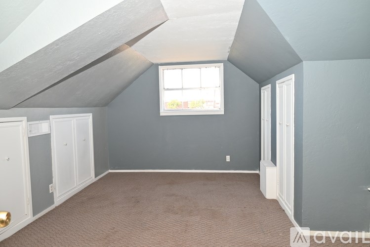 A room with a window and a carpeted floor.