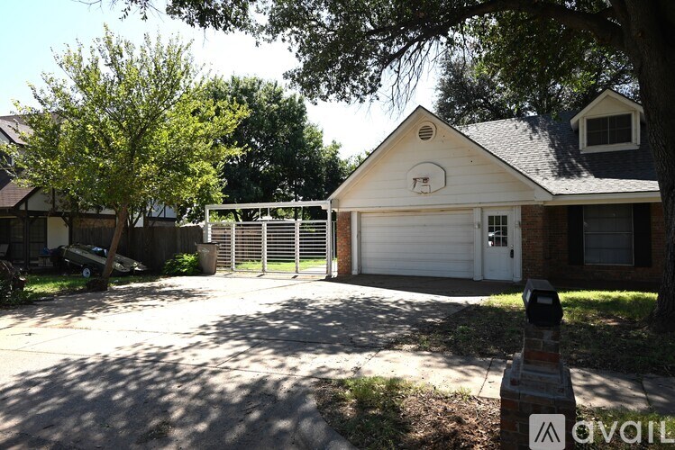 A house with a garage and a tree in front of it.