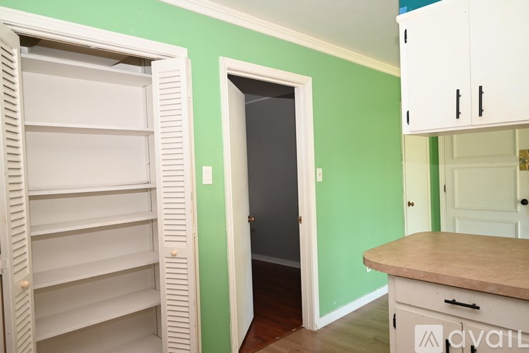 A room with green walls and a white cabinet with a drawer open.