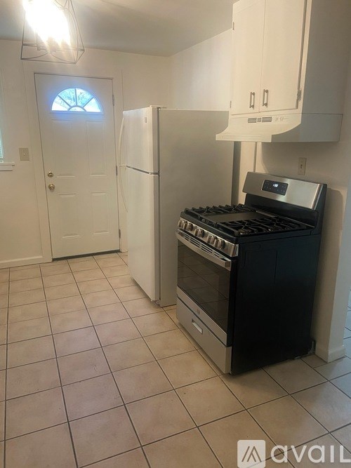 A kitchen with a black oven and white cabinets.