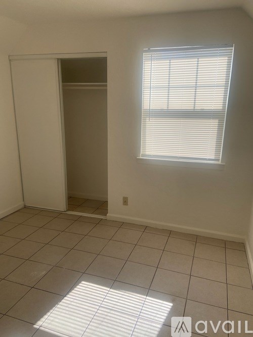 A room with a white door and a window with blinds.