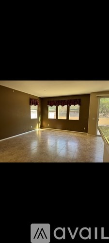 A room with a large window and a brown floor.