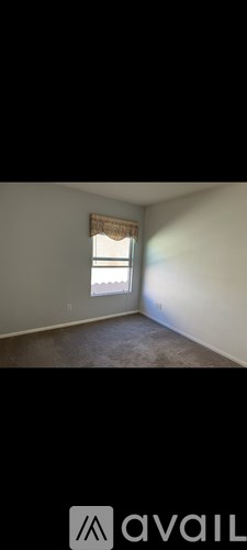 A room with a window and a wall-mounted air conditioner unit.
