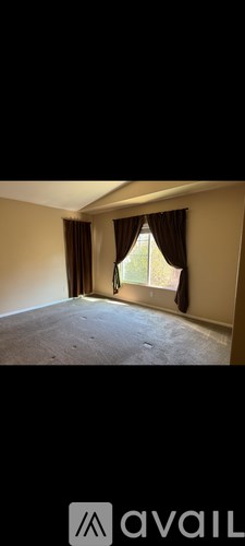 A room with a window and curtains.