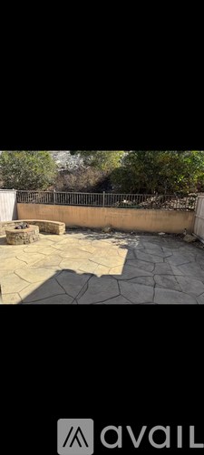 A cracked ground with a wall and trees in the background.