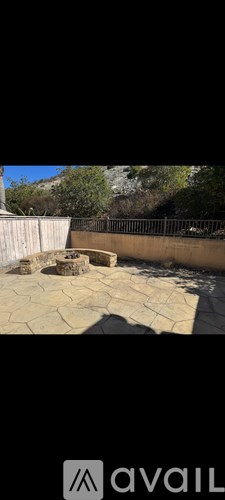 A patio with a stone floor and a wooden fence.
