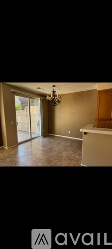 A room with a chandelier and a cabinet.