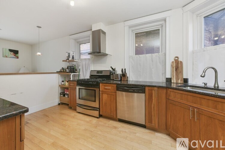 A kitchen with wooden cabinets and a black countertop.