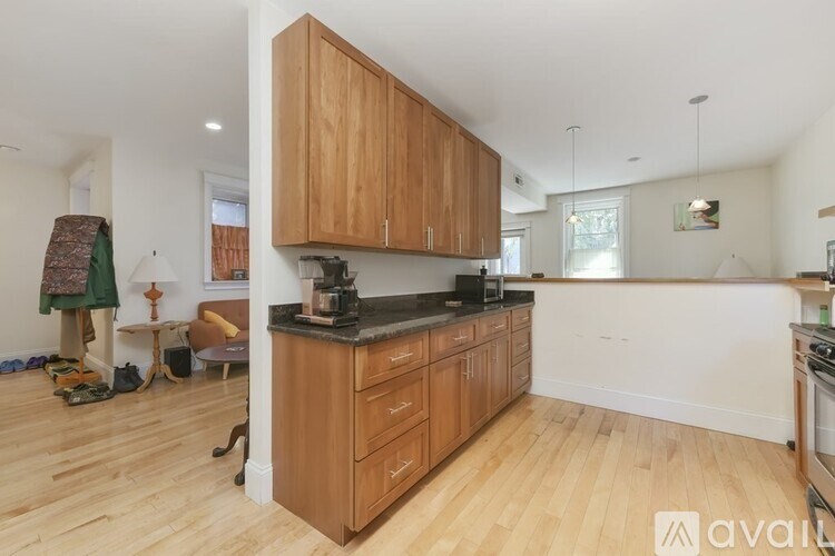 A kitchen with wooden cabinets and a black countertop.