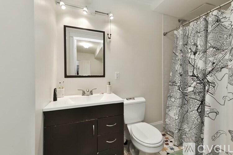 A bathroom with a sink, toilet, and shower curtain.