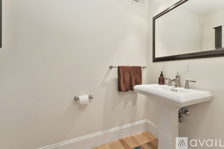 A bathroom with a white sink and a mirror.