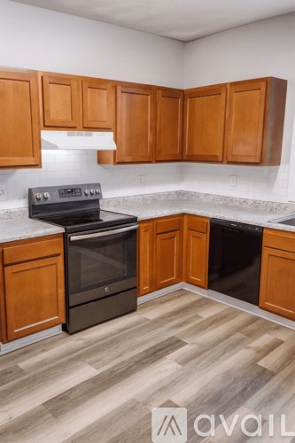 A kitchen with wooden cabinets and a black oven.