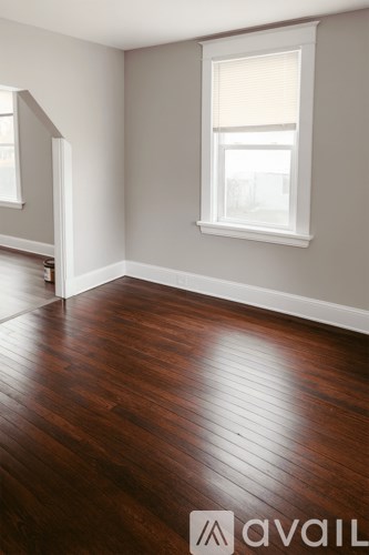 A room with wooden floors and a window.
