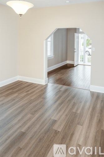 A room with wooden flooring and a white ceiling light.