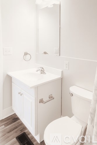 A white bathroom with a toilet and sink.