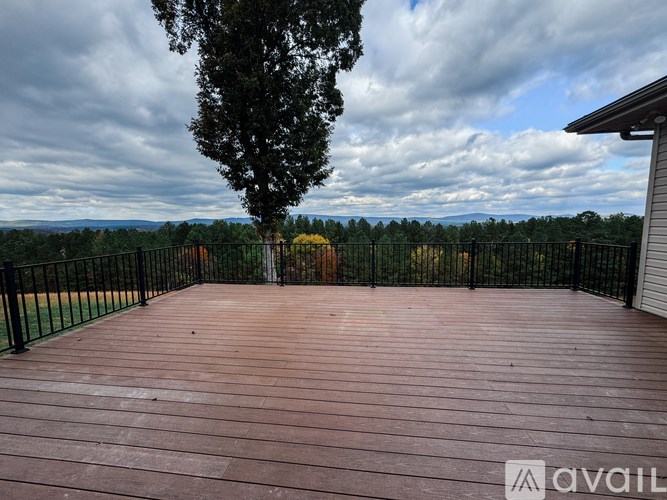A wooden deck with a tree and a fence in the background.
